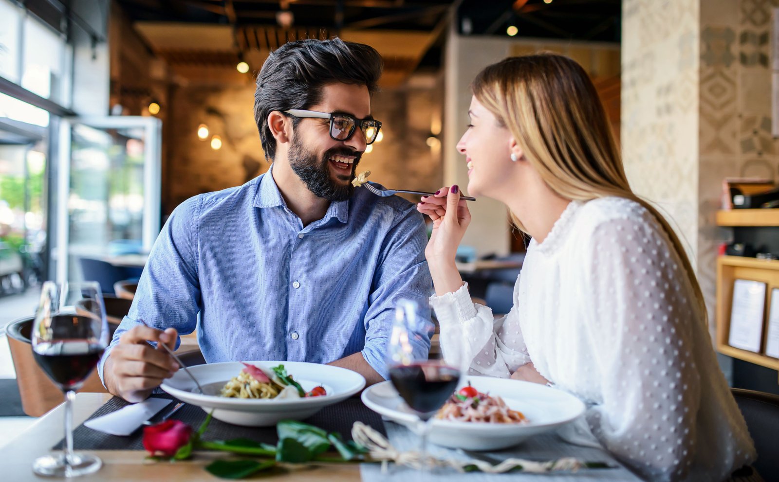 Husband and wife enjoying vegan meal and a glass of red wine.