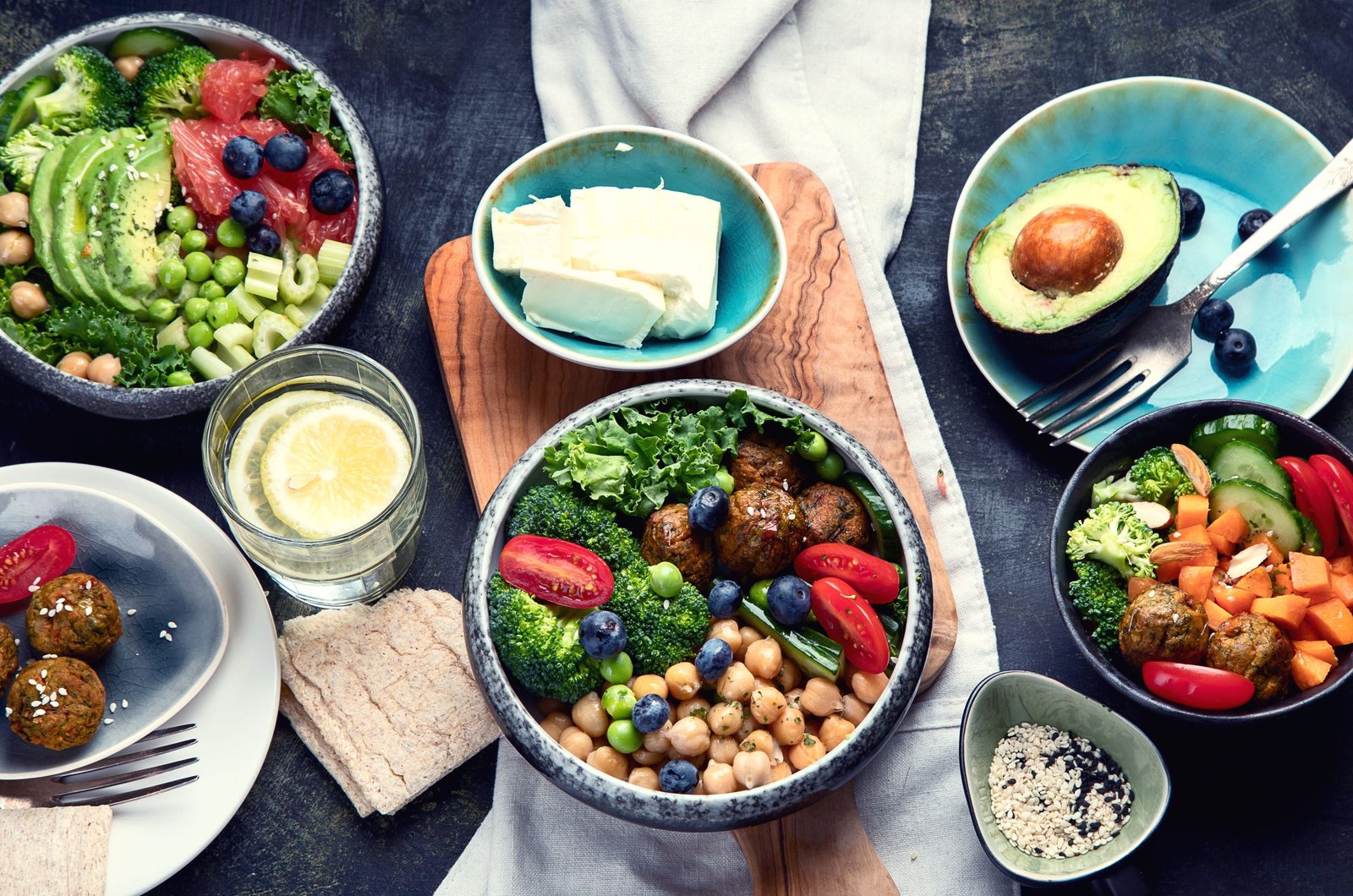 Table is set with assorted food, salad, cheese and beverages.