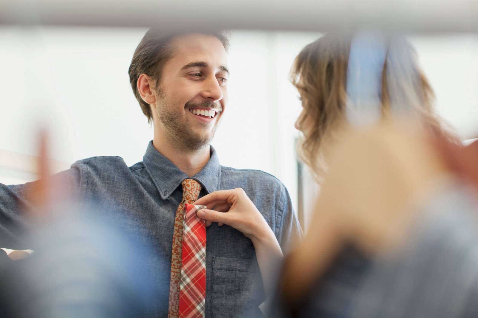 Couple trying to figure out what tie will better go with the shirt expressing their caring love