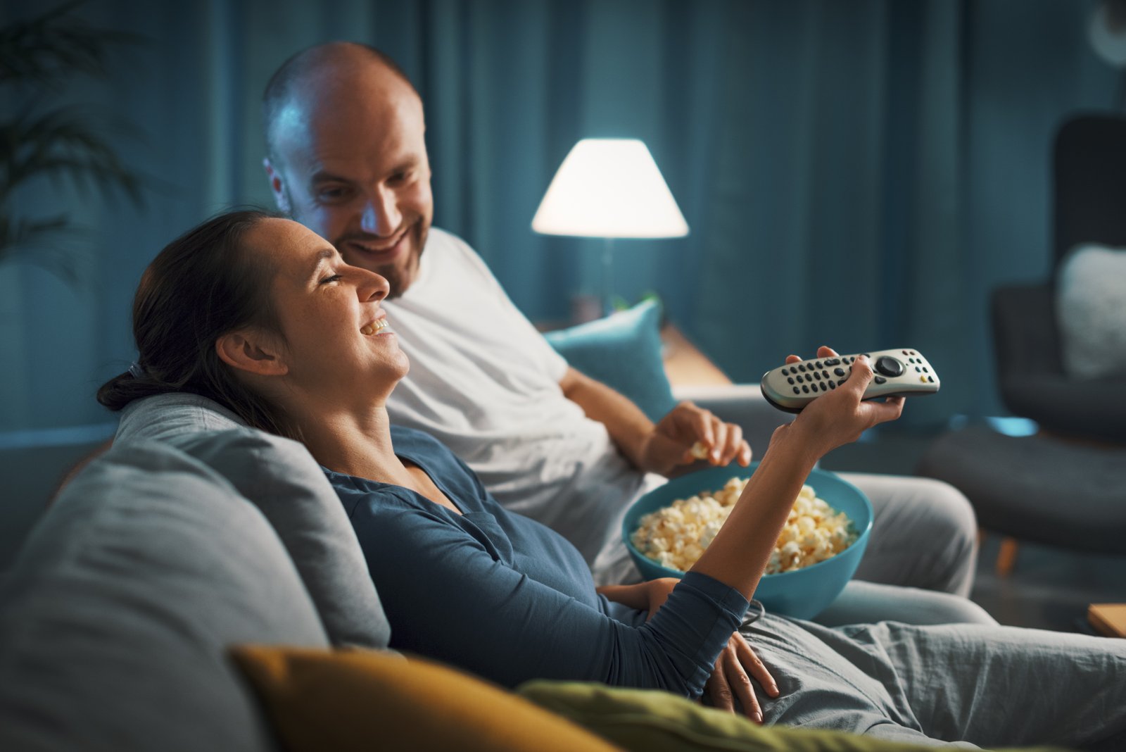 Couples happily laughing watching TV